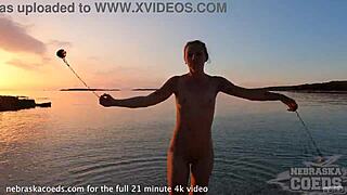 Sultry European beauty performs mesmerizing fire dance on nude beach at sunset