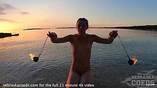 Sultry European beauty performs mesmerizing fire dance on nude beach at sunset