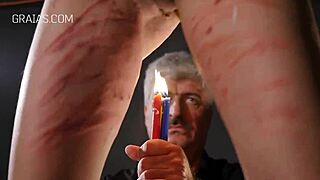 Redhead girl undergoes BDSM candle play in garage