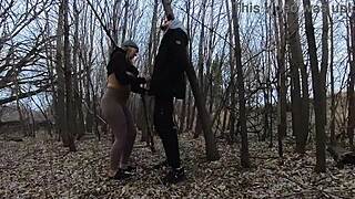 A blonde wife gives a blow job to her husband in a park.