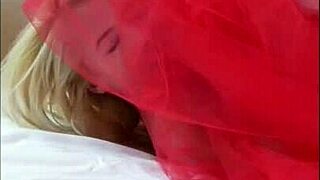 Beautiful woman Odettes has fun on the red bed and plays with her pussy