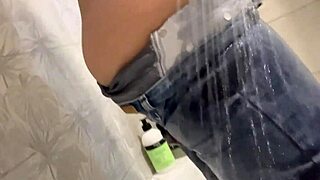 A solo girl enjoys a shower and wears wet jeans