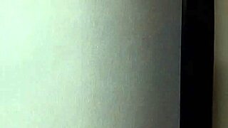 An amateur gives a blow job in front of a mirror