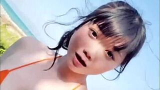 Japanese beauty shows off her big boobs and dances sexy by the pool