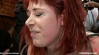 A red-haired girl is playing with a metal doggy cage